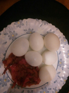 A picture of Boiled eggs and garlic tomato sauce.
