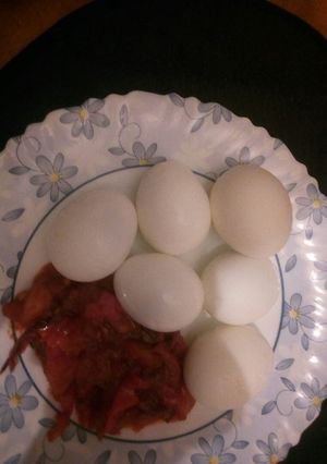 A picture of Boiled eggs and garlic tomato sauce.