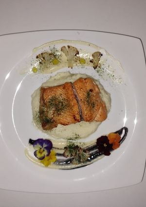 Una foto de Trucha en puré de coliflor y salsa blanquet con eneldo y tinta de calamar