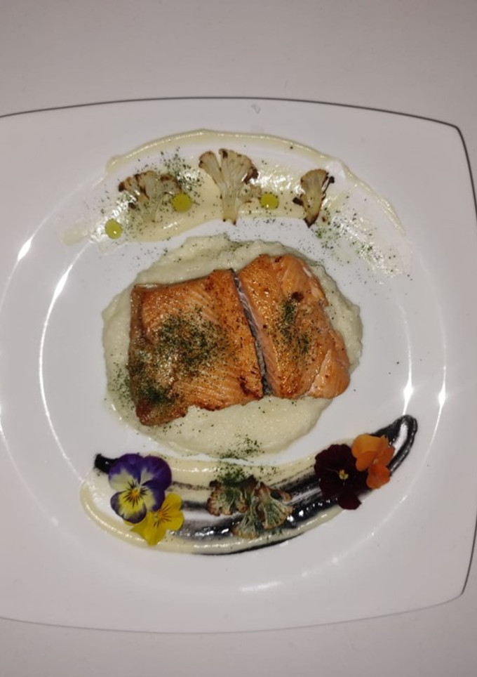 Una foto de Trucha en puré de coliflor y salsa blanquet con eneldo y tinta de calamar