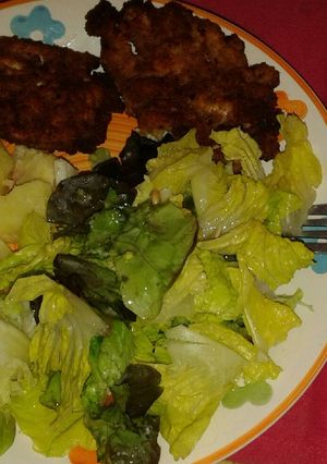 Una foto de Pollo apanado con ensalada