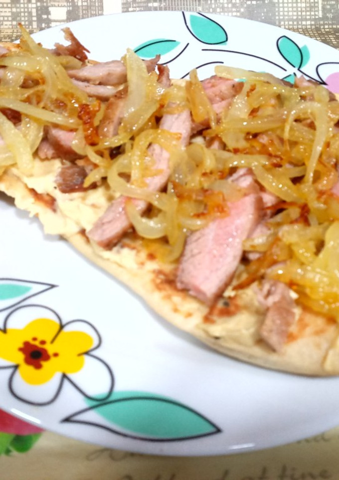Una foto de Pan naan con hummus, secreto ibérico y cebolla