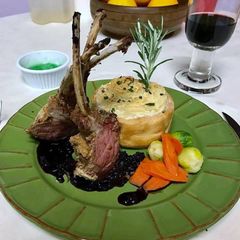 A picture of Rack of lamb with red wine sauce, garlic mashed potatoes, Brussels sprouts and carrots.