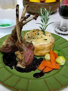 A picture of Rack of lamb with red wine sauce, garlic mashed potatoes, Brussels sprouts and carrots.