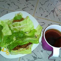 A picture of Fried Eggs wrapped in cabbage and lettuce with Tea.