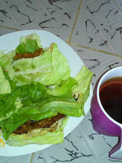 A picture of Fried Eggs wrapped in cabbage and lettuce with Tea.