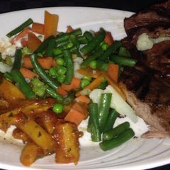 A picture of Masala chips,steamed veggies and pan fried steak.
