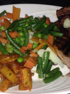 A picture of Masala chips,steamed veggies and pan fried steak.