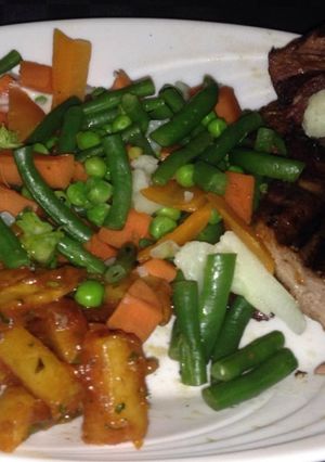 A picture of Masala chips,steamed veggies and pan fried steak.