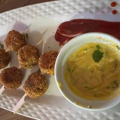 A picture of Chicken poppers with honey mustard sauce.