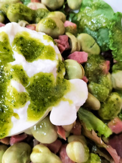 Una foto de Ensalada templada de habas trufadas con jamón, burrata y pesto con cacahuetes