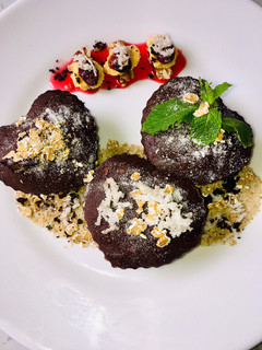 Una foto de Brownie de chocolate con coco y tierra de nueces y mermelada de fresa