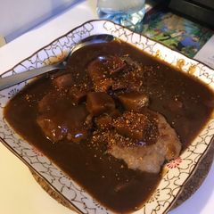 A picture of Pork patty with curry sauce.