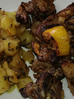 Una foto de Cabrito al ajillo y limón con patatas al horno