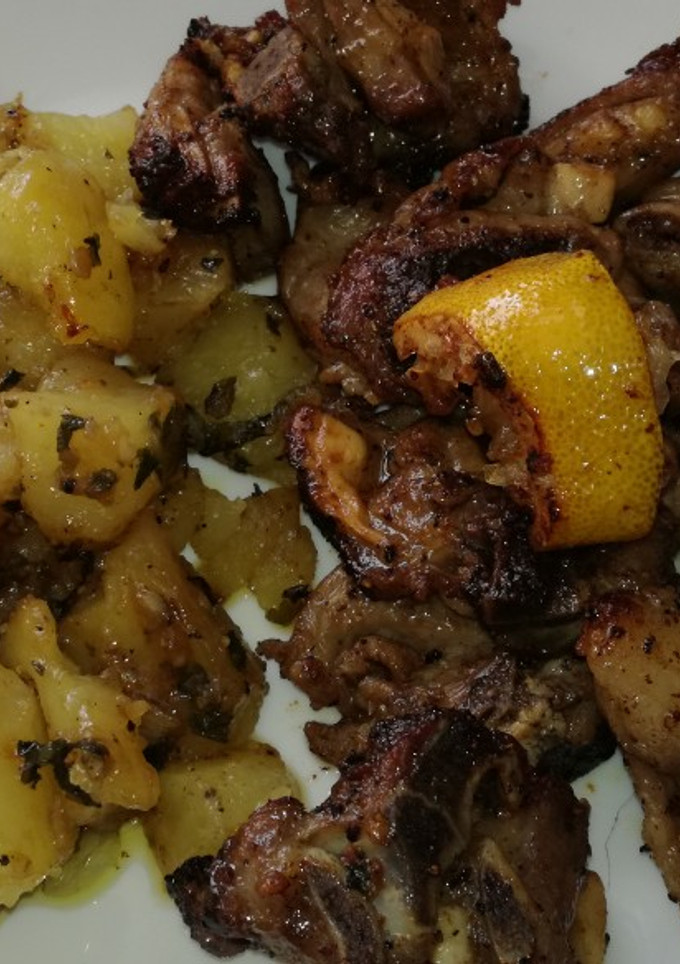 Una foto de Cabrito al ajillo y limón con patatas al horno