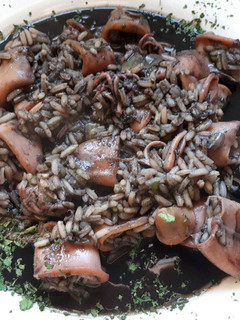 Una foto de Chipirones en su tinta con arroz