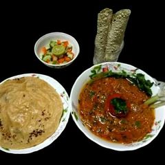 A picture of Mashed potato and tomato masala.