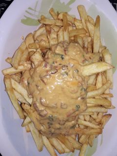 Una foto de Papas fritas con salsa cheddar