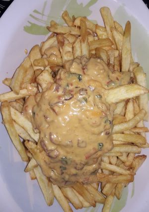Una foto de Papas fritas con salsa cheddar