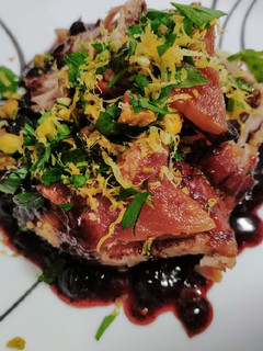 A picture of Roast pork with blueberry balsamic sauce and pistachio gremolata.