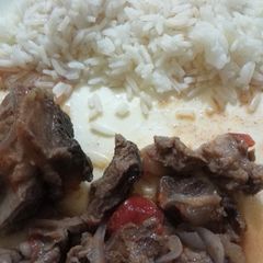 A picture of Beef stew served with Rice.