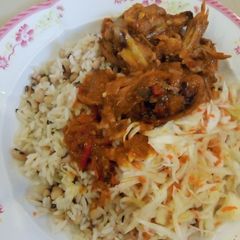 A picture of Rice and beans wit chicken souce and salad.