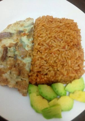 A picture of Jollof rice with fried egg and avacado.