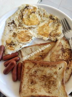 A picture of French toast, omelette and sausages.