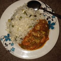A picture of Scotch rice with chicken curry.
