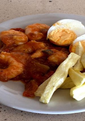 Una foto de Pisto con langostinos, huevo y papas fritas