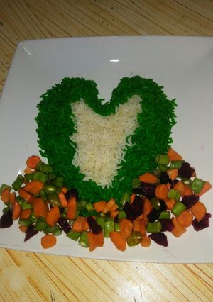 A picture of Green and white rice with vegetable sauce.