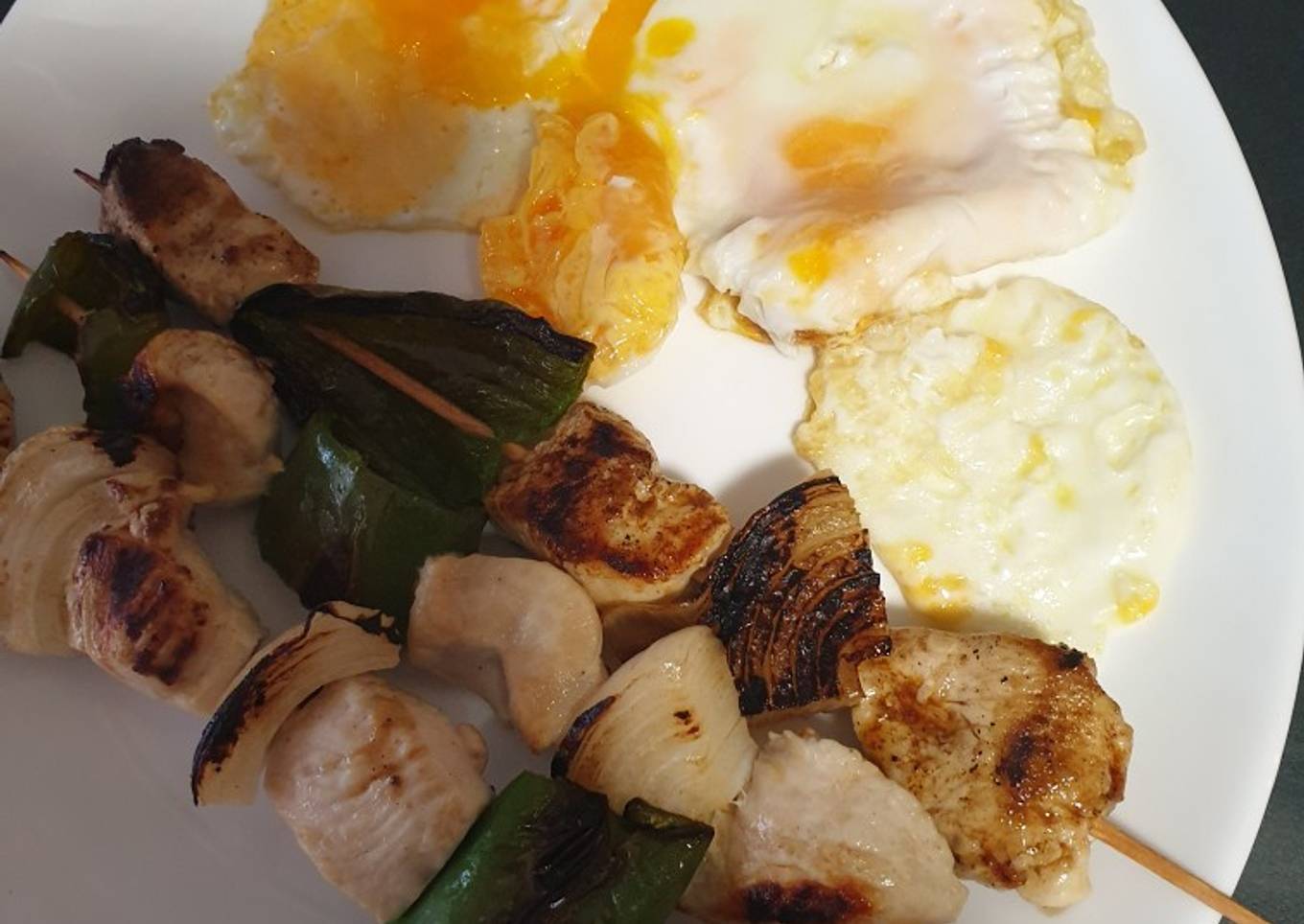 Brochetas de pollo con un huevo frito