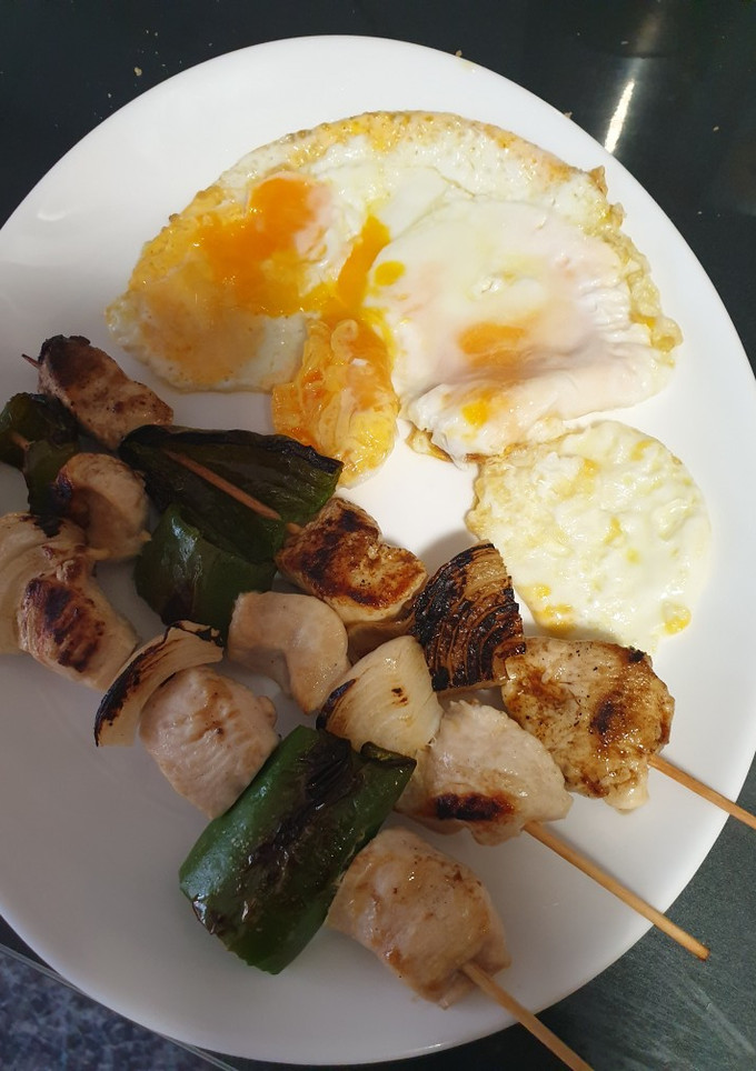 Una foto de Brochetas de pollo con un huevo frito