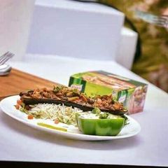 A picture of Brinjal potatoes in Boat with riceBrinjal raita serves in capsicum cup.