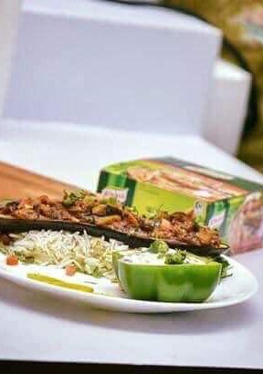A picture of Brinjal potatoes in Boat with riceBrinjal raita serves in capsicum cup.