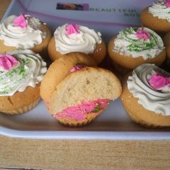 A picture of Vanilla cupcakes with cream frosting.