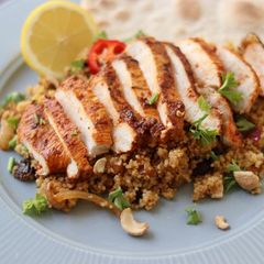 A picture of Harissa chicken with couscous and flatbread.