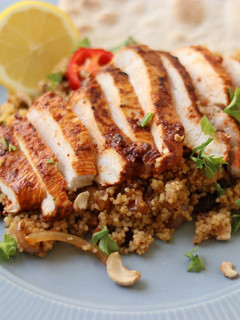 A picture of Harissa chicken with couscous and flatbread.