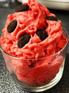 Una foto de Helado de fresas naturales, base de galletas con canela y topping de chocolate negro