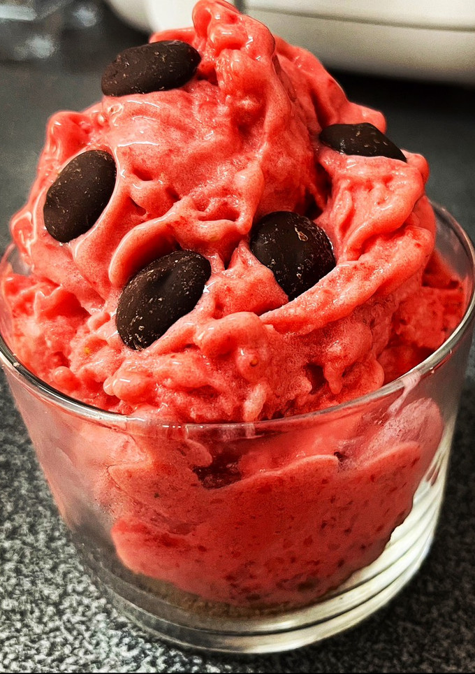 Una foto de Helado de fresas naturales, base de galletas con canela y topping de chocolate negro
