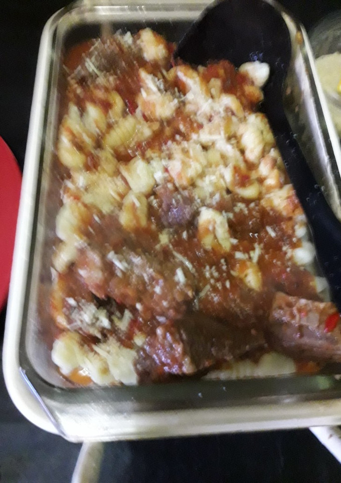 Una foto de Ñoquis de papa con salsa roja y carne