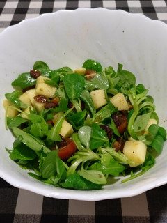 Foto principal de Ensalada de rúcula, canónigos, tomate, manzana y uvas pasas