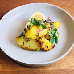 A picture of Potatoes with lemon, herbs and sprouts 🌿.