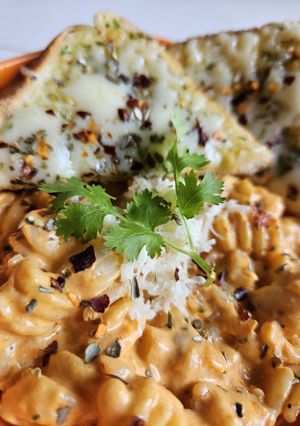 A picture of Pink sauce Pasta with Cheesy Garlic Bread.