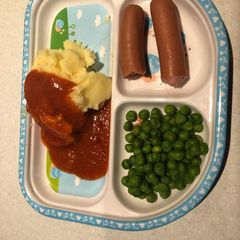 A picture of Mashed potatoes and peas with chicken sausage.