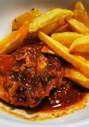 Una foto de Pollo Frito en Salsa de Tomate & Papas Fritas