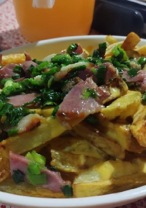 Una foto de Papas con Cheddar, Panceta y cebollita de Verdeo