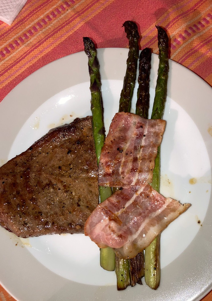 Una foto de Espárragos grillados con tocino y Bife.
