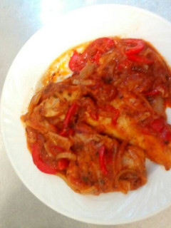 Una foto de Filete de Merluza con pimiento rojo y cebolla