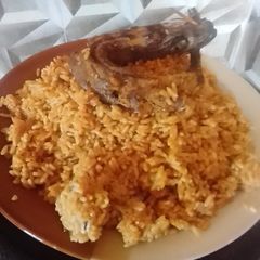 A picture of Jollof rice with fried fish.